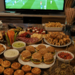 Buffet apéritif pour regarder un match de football avec mini burgers, nachos, feuilletés, crudités et planche apéro devant la télévision.